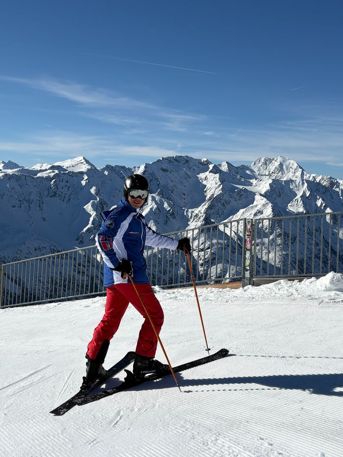 Antonio auf dem Gipfelplateau vor verschneiten Bergen